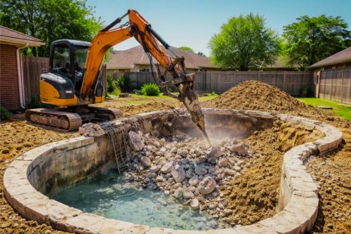 Residential backyard swimming pool demolition in Houston with excavator breaking concrete pool structure during professional demolition work